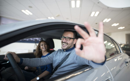 Happy customer buying new car at dealership.